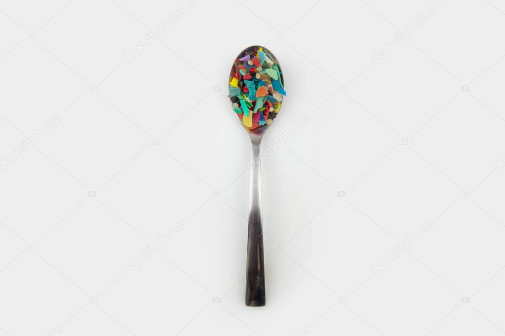 Spoon full of microplastics. Plastic pollution concept.