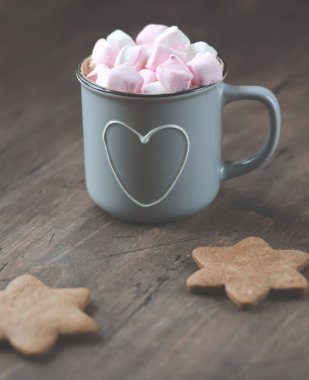 Metal fincan kakao ahşap bir masa üzerinde Noel gingerbread ile rahat. Marshmallow ile.