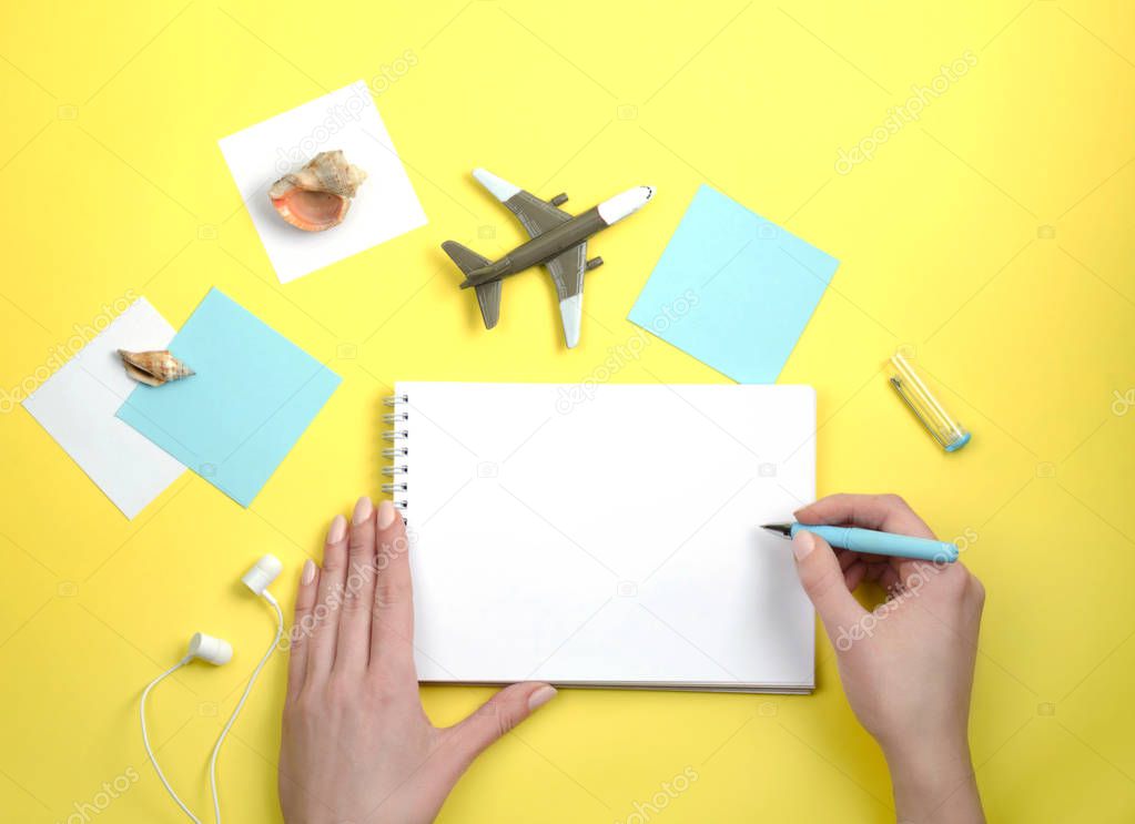 Writing in a white notebook. About travel. Small aircraft