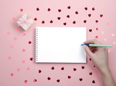 Pembe bir arka plan üzerinde yazmak için beyaz Not defteri.