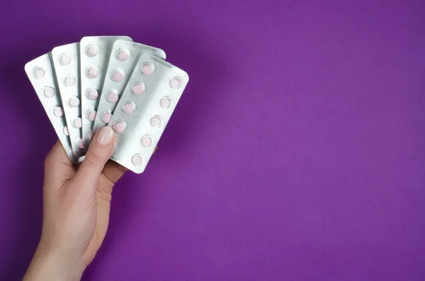 Mor bir arka plan üzerinde beyaz tabletler çeşitli vitamin
