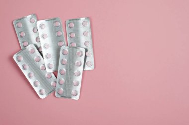 Vitaminler paket yumuşak pembe bir arka plan üzerinde pembe.