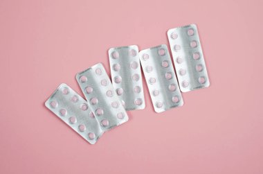 Vitaminler paket yumuşak pembe bir arka plan üzerinde pembe.