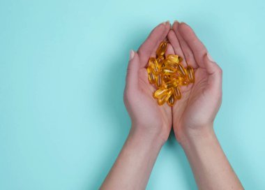 Tablet mavi zemin üzerine sarı balık yağı. Vitaminler