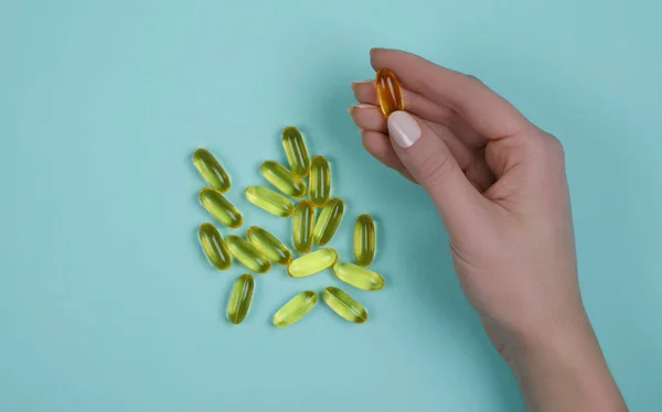 Tablet mavi zemin üzerine sarı balık yağı. Vitaminler