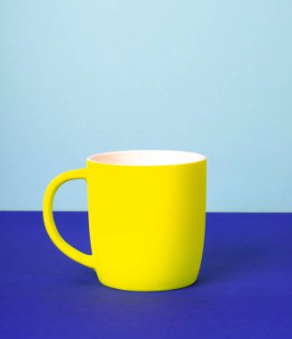 Katı pastel arka plan üzerinde yeni sarı Kupası.