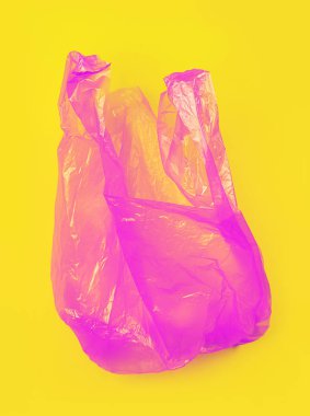 Sarı arka plan üzerinde parlak pembe plastik torba.