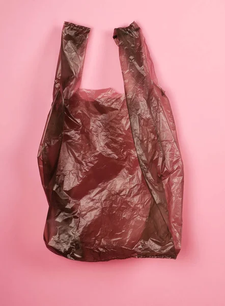 Élénk szürke műanyag zsák vörös háttérrel. — Stock Fotó
