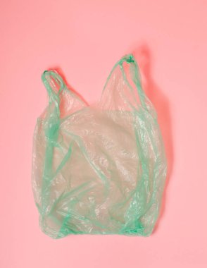 pembe arka plan üzerinde yeşil plastik torba. Parlak