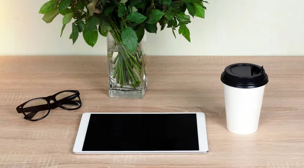 Escritorio de madera. Comprimido blanco con gafas de borde negro. Copa blanca de café . —  Fotos de Stock