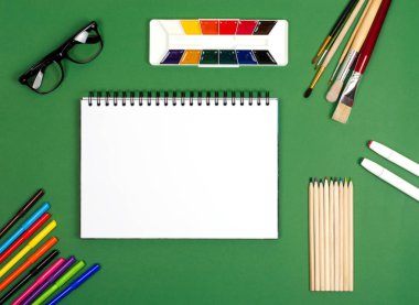 Çizim için boya ve fırçalı beyaz defter. Yaratıcılık konusunda fotoğraf.