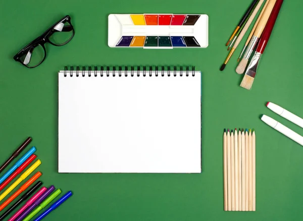 White notebook with paints and brushes for drawing. The photograph on the subject of creativity. — Stock Photo, Image