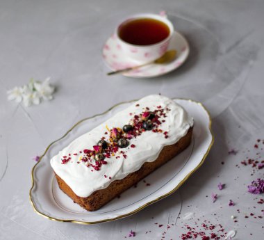 Gri bir masada bir fincan çay ile beyaz krema ile Lezzetli kek