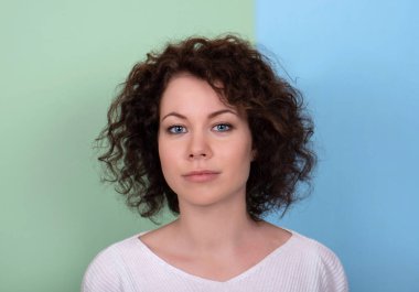 Kıvırcık siyah saçlı genç bir kız. Yüzü yakın çekim.