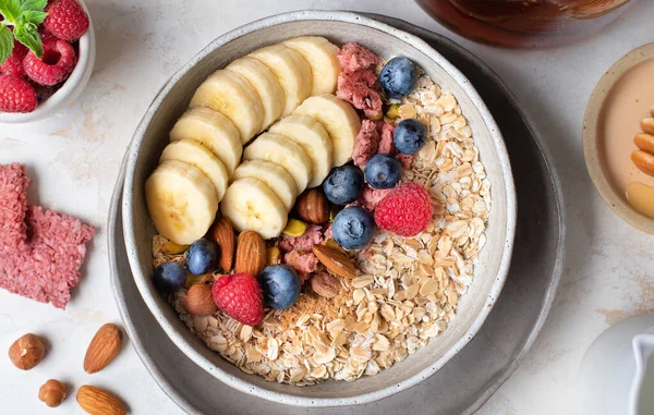 Sağlıklı beslenme. Yulaf ezmesi. Yulaf lapası malzemeleri. Sağlıklı bir kahvaltı. Lezzetli yaz meyveleri. Faydalı fındık.