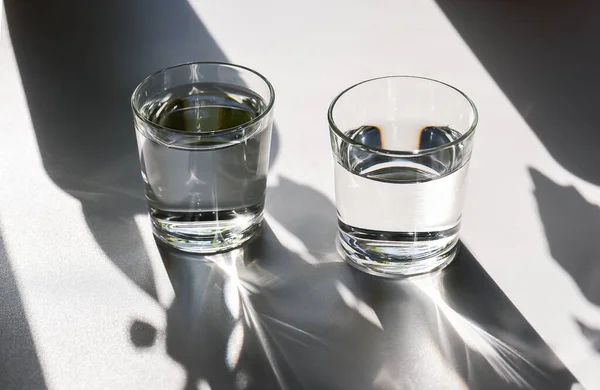 Dois copos de água claros. Luz solar brilhante. — Fotografia de Stock