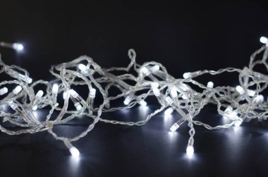 Siyah arka planda ışıklar olan Noel çelengi.