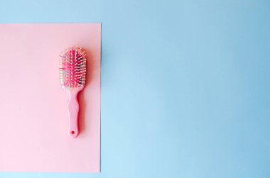 Pembe-mavi arka plan üzerinde pembe saç fırçası.