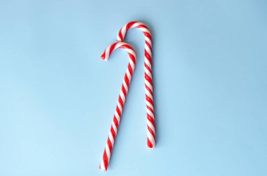 Mavi bir arka plan üzerinde iki baston şekerler.