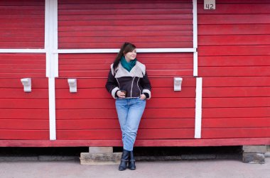 Artı boyutu model bir kışın içecekler kahve ahşap bir kırmızı ev yakınındaki bak.