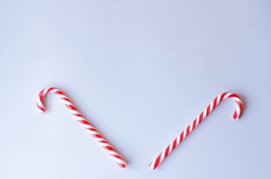 Beyaz ve gri arka plan üzerinde kırmızı iki baston şekerler. Yeni yılın tarzı.