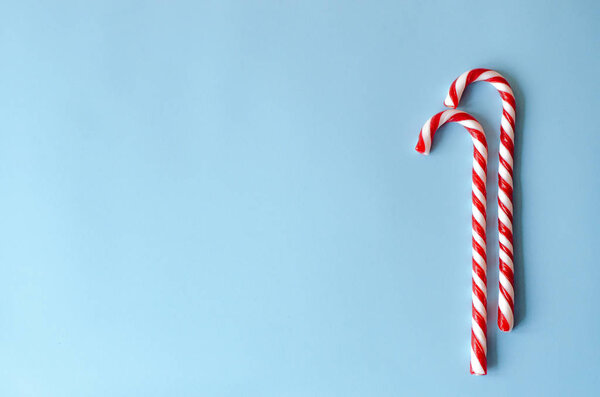 Две конфеты из трости в белом и красном на синем фоне. Новогодний стиль
.