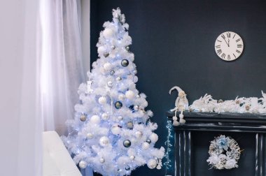 Şömine yakın oyuncaklar ile beyaz Noel ağacı. Bir saat içinde şömine kilitleniyor. Yeni yıl.