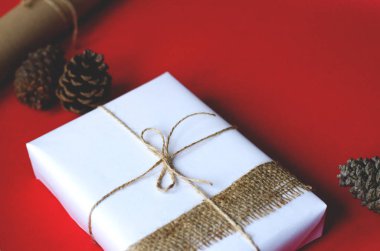 Hediye kırmızı bir arka plan üzerinde retro tarzı tıka basa dolu. Yakın birkaç koniler ve katlanmış el sanatları Hediyelik kağıt?.