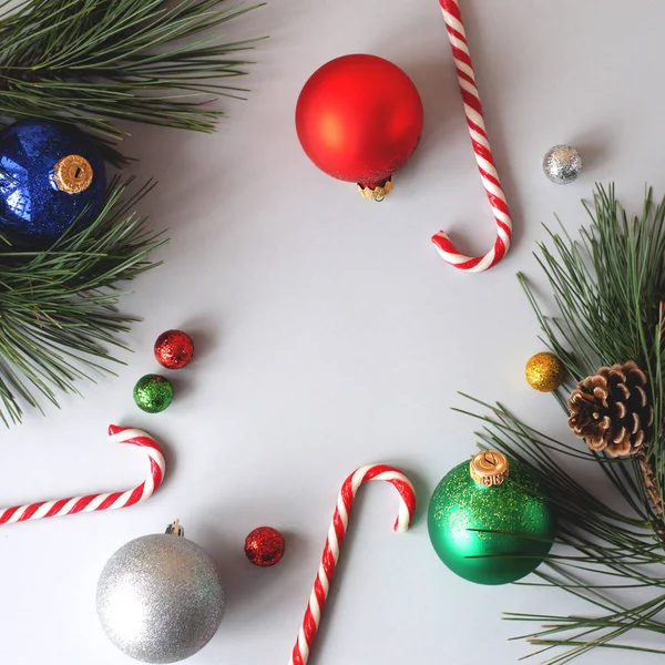 ボールの形と灰色の背景にクリスマス ツリーの枝にマルチカラーのおもちゃのクリスマス Fletley — ストック写真