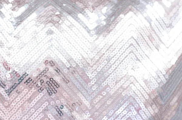 Fabric texture with shimmering silver sequins. Background with sequins.