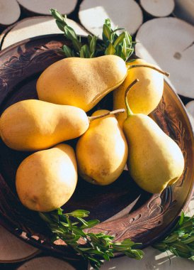 Bir tepenin bir rustik tarzı ahşap kesim bir zemin üzerine sarı armut ile kil kahverengi plaka.