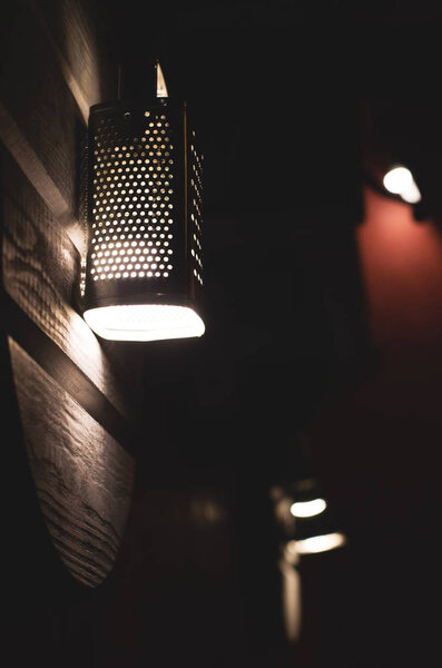 Kitchen grater in the form of a lamp in a dark room. Creative design.