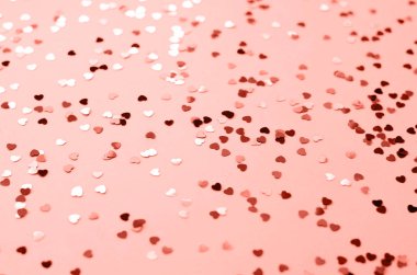 Mercan bir arka plan üzerinde birçok küçük parlak kupa. Mercan rengi yılın trend renktir. Sevgililer günü.