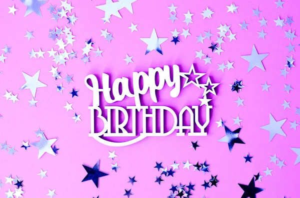 Inscription Happy Birthday on a pink background with twinkling silver stars.