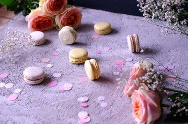 Bademli kurabiye çok gri beton zemin üzerine güzel şeftali renkli gül buketi ile.