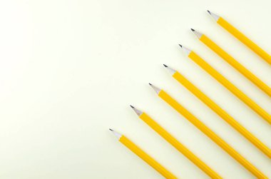 Bir satır sarı bir arka plan üzerinde aynı düz kalemler. 