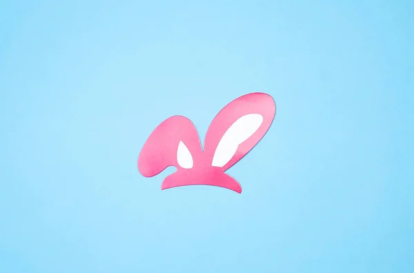 Papel orelhas de coelho rosa em um fundo azul . — Fotografia de Stock