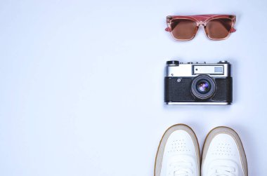 Düz ile kamera, gözlük ve spor ayakkabı gri bir arka plan üzerinde göklere.