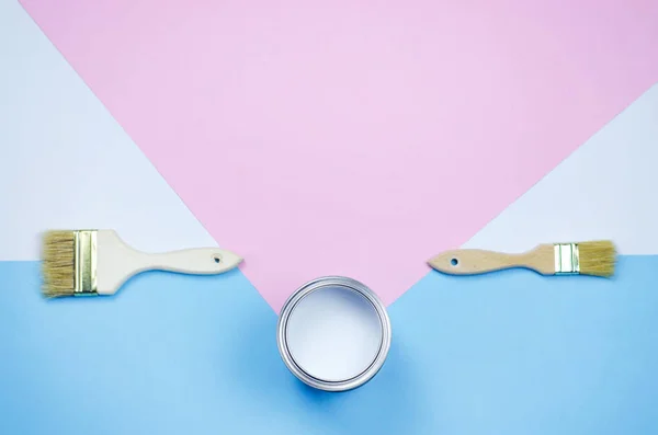 A can of white paint with tassels on a pink-blue with a white background. — Stock Photo, Image