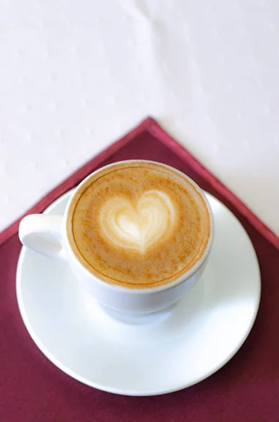 Filiżanka cappuccino z spienieniem i wzorem w kształcie serca. — Zdjęcie stockowe