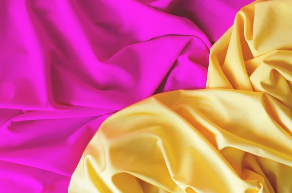 Φόντο από σατέν ύφασμα από κίτρινο και ροζ χρώμα. — Φωτογραφία Αρχείου