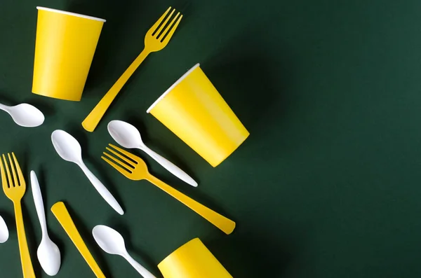 Flat lay plastic and paper utensils on a green background. — Stock Photo, Image