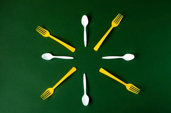 Plastic spoons and forks are laid out in the shape of a circle. — Stock Photo, Image