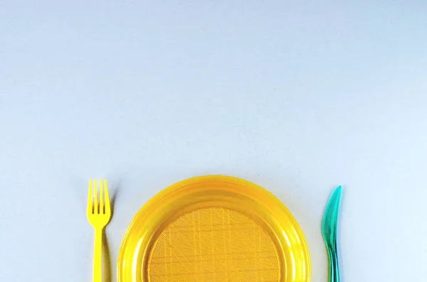 Utensilios de plástico y bolsa de plástico sobre fondo gris —  Fotos de Stock