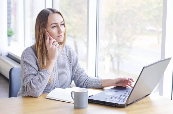 The girl sits working at the computer. — 스톡 사진