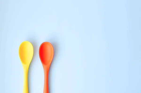 Fletley from multi-colored spoons on a blue background. — Stock Photo, Image