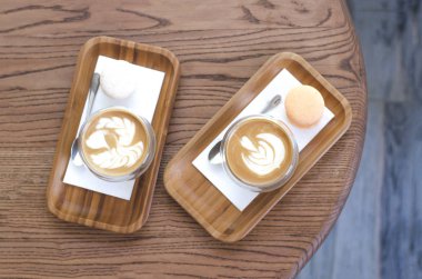 Ahşap standlarda köpük ve desen standı ile iki kahve.