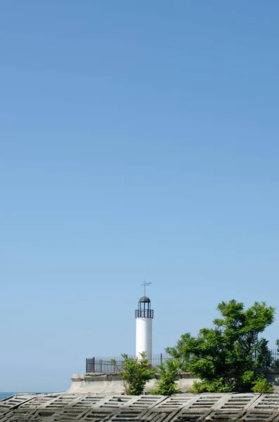 Weißer Leuchtturm am Meer mit blauem Himmel. — Stockfoto