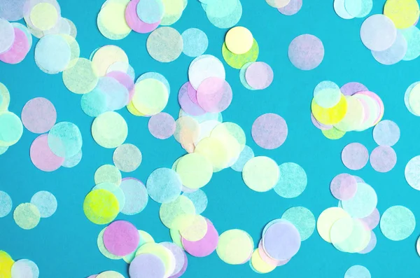 Turquoise background with many round multicolored confetti.