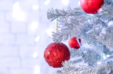 Beyaz duvarın yanında oyuncaklarile Noel ağacının bir parçası.